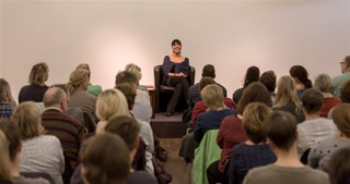 Maria Sanchez im Seminar beim Vortrag in einer größeren Gruppe von Personen. Größe: 320 x 169 Pixel